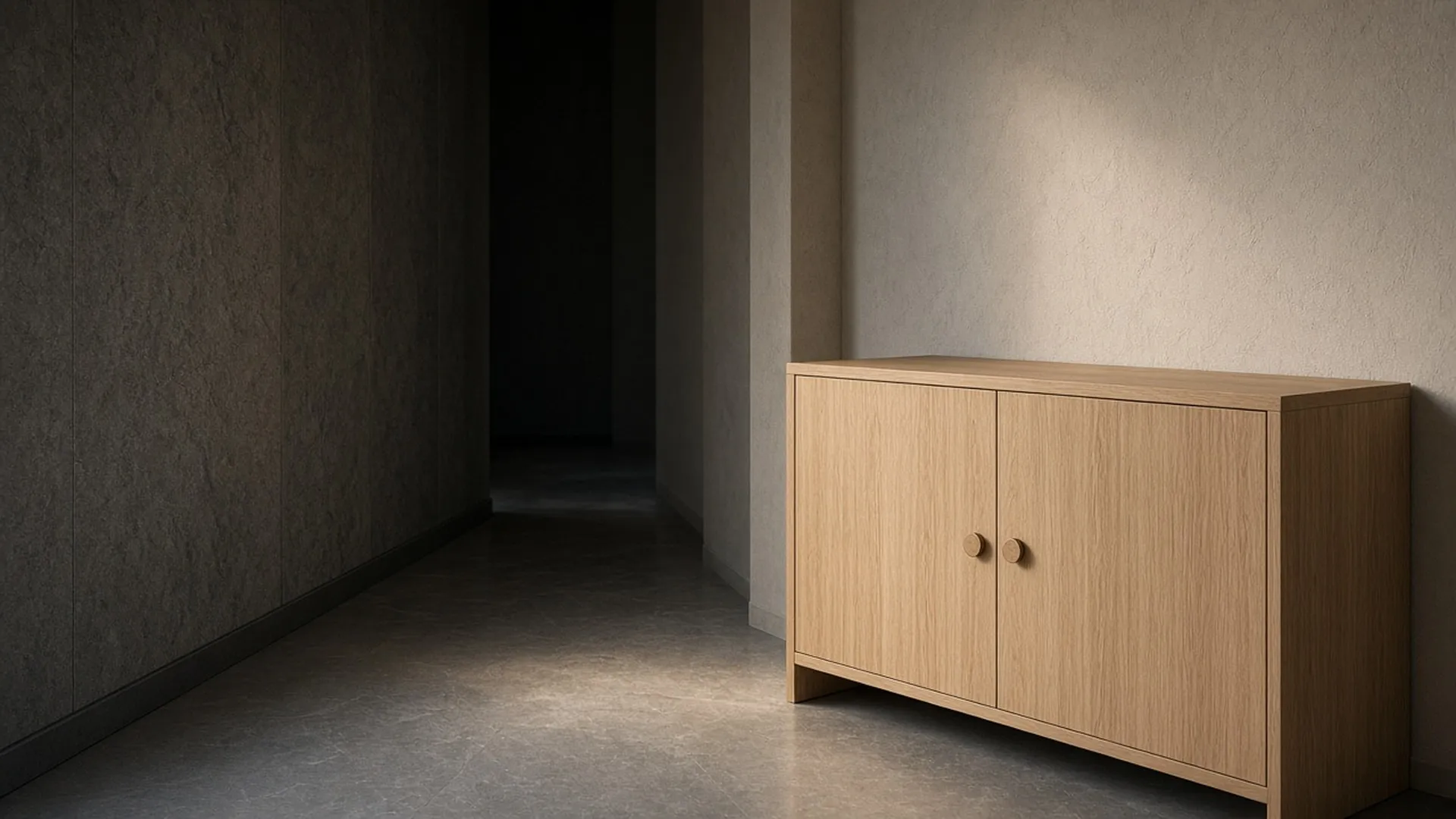 A closed pale oak cabinet with plain round knobs in a quiet hallway